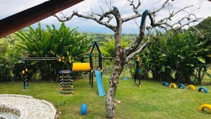 Un parque infantil con una estructura de escalada, toboganes y columpios de neumático.