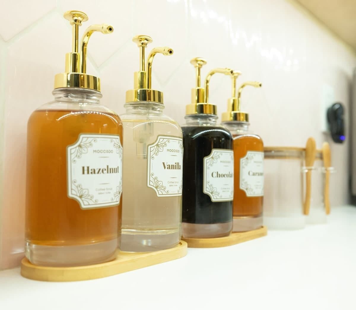 A row of perfume bottles with gold pumps on a white surface.