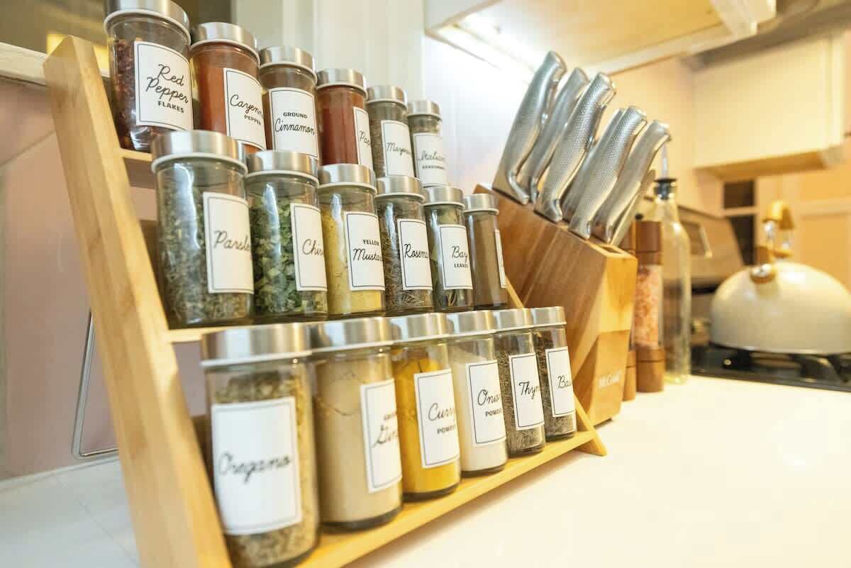 A spice rack with labeled jars of various spices.