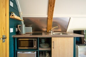 Une petite cuisine équipée d’un four à micro-ondes, d’un grille-pain et d’un évier.