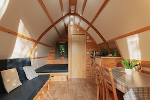 Un acogedor cuarto ático con sofá, mesa de comedor y kitchenette.