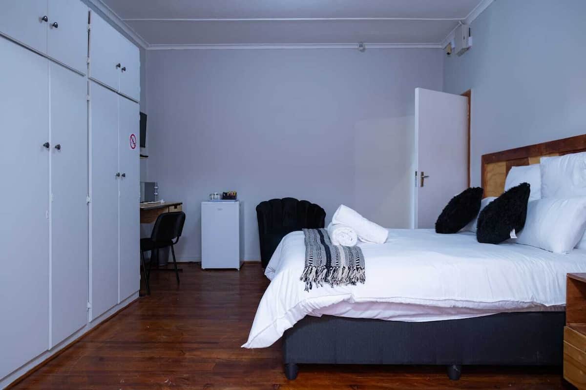 Ein Schlafzimmer mit einem Bett, einem Schreibtisch, einem Stuhl und einem Kleiderschrank.