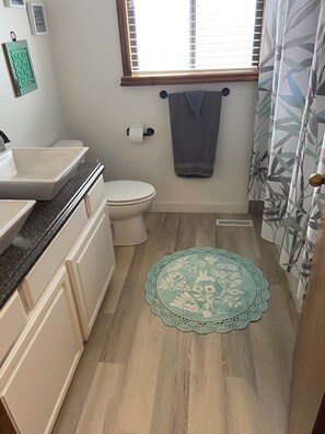 Een badkamer met een wastafel, toilet en een handdoek aan de muur.
