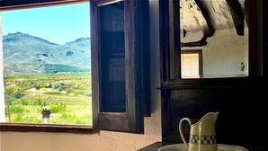 Una habitación con ventana que da a un paisaje montañoso.