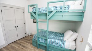 A room with a bunk bed, a white door, and a wooden floor. - FREE Heated Pool! Sleeps 14 with Game Room! Close to Pier Park, Beaches & 30A! (Panama City Beach)