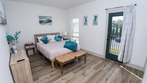 A bedroom with a bed, bedside table, lamp, and a bench. - FREE Heated Pool! Sleeps 14 with Game Room! Close to Pier Park, Beaches & 30A! (Panama City Beach)