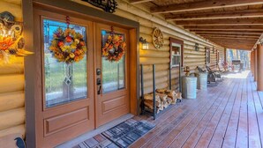 A log cabin with a porch, two glass doors with wreaths, a welcome sign, and a wooden bench. - Oakland Bear Lair|7BR Luxury Log|Pool, Hot tub (Oakland)