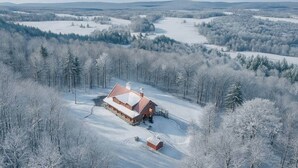 A cabin with a snow-covered roof, surrounded by a forest and a snow-covered landscape. - Oakland Bear Lair|7BR Luxury Log|Pool, Hot tub (Oakland)