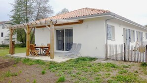 A single-story house with a covered patio, a fenced yard, and a white exterior. - La scierie - SABRES - Gîte (SABRES)