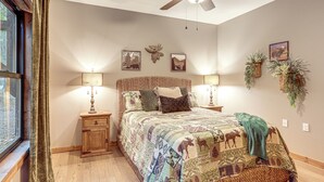 A bedroom with a large bed, two bedside tables, a ceiling fan, and wall-mounted plants. - Lake Views & Golf Access at Secluded Drasco Lodge (Drasco)