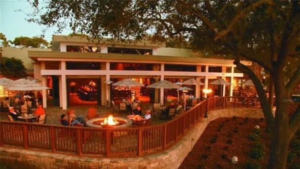 Un patio al aire libre con una chimenea, asientos y sombrillas.