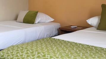 Ein Hotelzimmer mit zwei Betten, einem kleinen Tisch und einem an der Wand hängenden Gemälde.