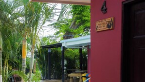 A pool area with a red wall, a door labeled "4", and a sign that reads "PURA VIDA Costa Rica". - APARTMENT EL JOBO, LA CRUZ, AT 700 MTRS COPAL BEACH, 8 MIN FROM RAJADA (Provincia de Guanacaste)