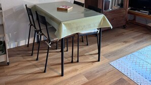 Un comedor con una mesa, sillas, un armario y un televisor.