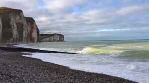 A rocky beach with white cliffs and a pebbly foreground. - Gîtes de France® - Waves and Furrows (ST MARTIN AUX BUNEAUX)