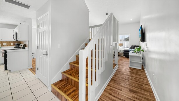 A modern interior with a staircase, white walls, and wooden flooring. - "Casa Verde" - Private Pool - West End (Panama City Beach)