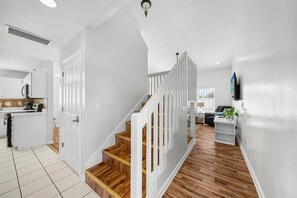 A modern interior with a staircase, white walls, and wooden flooring. - "Casa Verde" - Private Pool - West End (Panama City Beach)