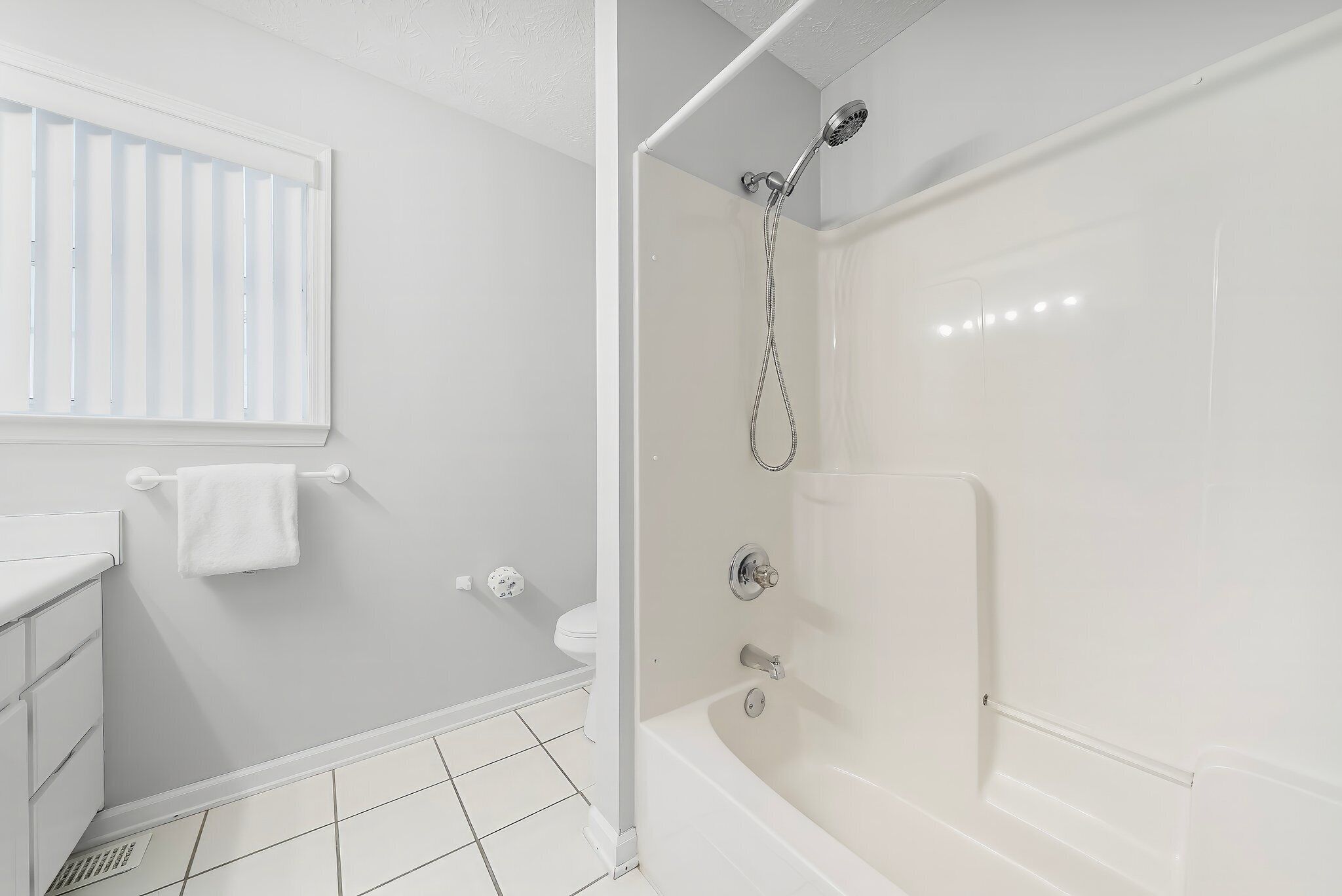 A bathroom with a shower, toilet, and sink.