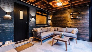 A modern living room with a sectional sofa, a coffee table, and a wooden ceiling.