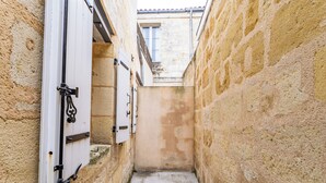 A narrow alleyway with stone walls and a tiled floor. - Duplex flat for 2 people with terrace and parking (Bordeaux)
