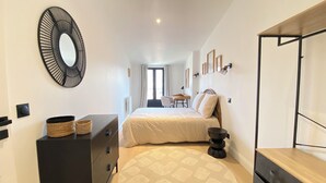 Un dormitorio con cama, cómoda, espejo y vistas a un balcón.