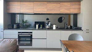 Una cocina moderna con horno integrado, cafetera y microondas.