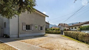 A residential area with a house featuring a gravel driveway and a hedge. - MAISON MARMILLONS - CANOPEE (AIX LES BAINS)