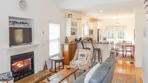 A spacious living room with a fireplace, a sofa, a coffee table, and a television. - 4BR Innsbruck | Closest to Helen | Private Hot Tub | Pool, Tennis & Pickleball (Helen)