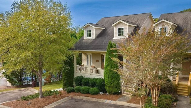 A two-story house with a front porch, a garage, and a well-maintained lawn. - 4BR Innsbruck | Closest to Helen | Private Hot Tub | Pool, Tennis & Pickleball (Helen)