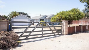 Un lotissement résidentiel fermé, doté d’un garage, d’un portail en bois et d’un arbre aux fleurs jaunes.