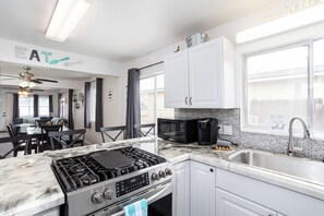 Enjoy meals in this well-equipped kitchen with a gas stove, microwave, and large window offering a view of the outside.