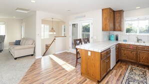Una cocina moderna con armarios de madera, una isla integrada y vistas al exterior.