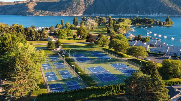 A tennis court complex with multiple courts, surrounded by trees and a lake view. - Bright Water Sunrise Home at Wapato Point Resort 5-bed Close to Sandy Beach/Pool (Manson)