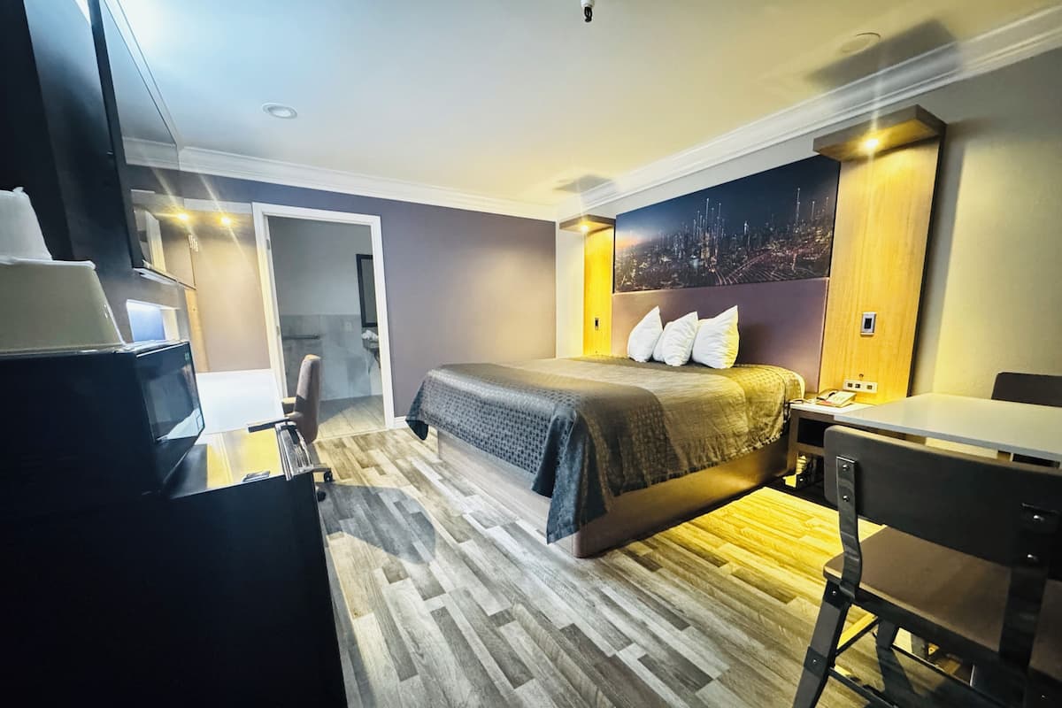Ein Hotelzimmer mit einem Bett, einem Schreibtisch und einem Fernseher.