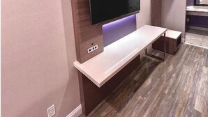 Una sala de estar moderna con un televisor de pantalla plana montado en una pared decorativa de madera, una consola blanca y un banco empotrado.