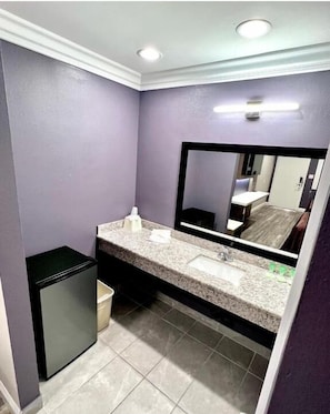 Bañera con ducha, toallas, jabón, shampoo