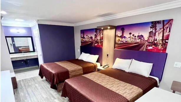 Habitación de hotel con dos camas, un escritorio y una silla.