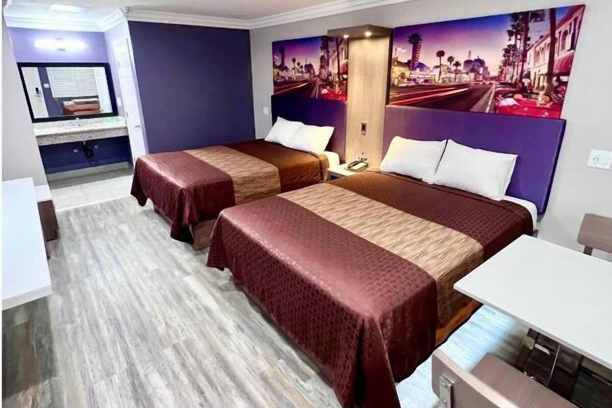 Ein Hotelzimmer mit zwei Betten, einem Schreibtisch und einem Stuhl.