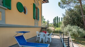 A building with a balcony, outdoor seating, and a staircase leading to a garden. - Holiday Home 'Ruben' with Shared Pool, Private Terrace and Wi-Fi (Fucecchio)