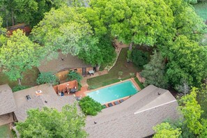 Ein Wohnhaus mit Swimmingpool, Terrassenbereich und überdachter Sitzgelegenheit im Freien.