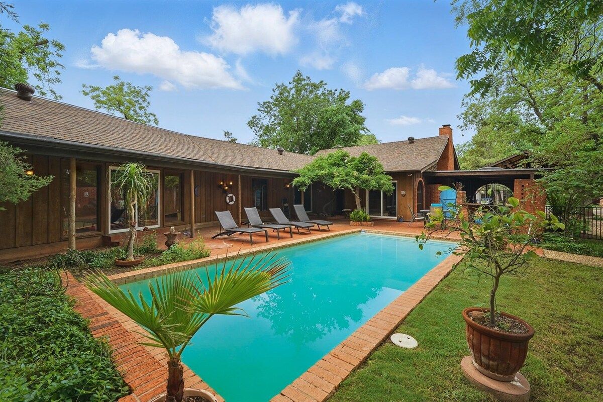 Un patio trasero con piscina, sillas de descanso y una construcción de madera.