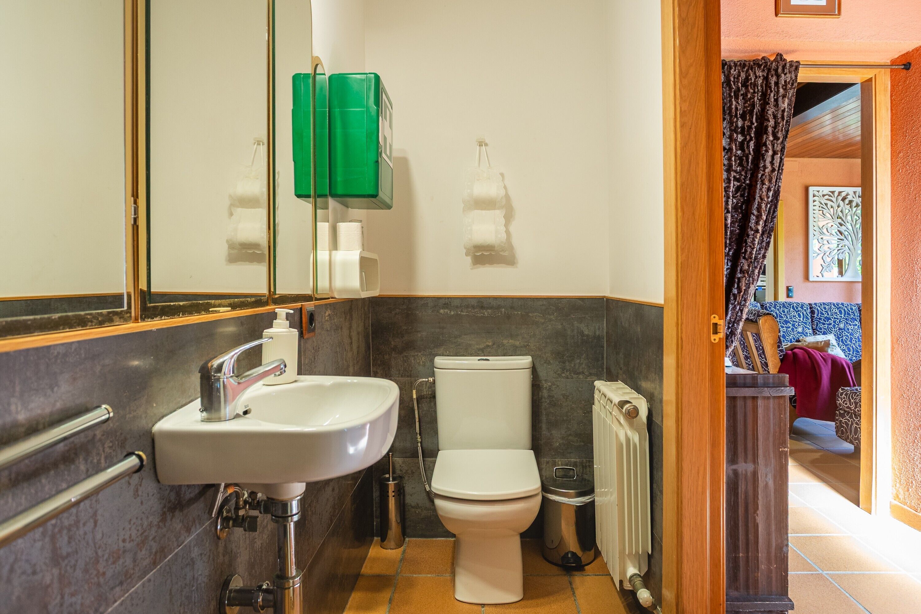 A bathroom with a sink, toilet, and radiator.