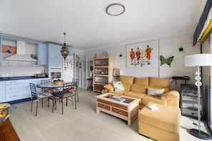 Ein modernes Wohnzimmer mit Sofa, Couchtisch und Essbereich mit Stühlen.