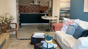 Un salon moderne avec un canapé, une petite table, un vase décoratif et une valise.