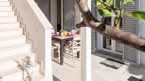 A staircase leading to a dining area with a table set for two, surrounded by chairs. - Pianosa I by Interhome (Follonica)
