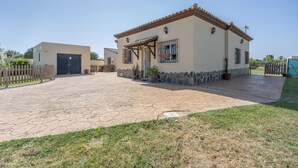 Una casa con camino de entrada pavimentado, garaje y muro de piedra.