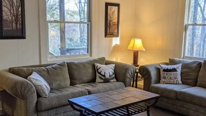A living room with two couches, a coffee table, and a lamp.
