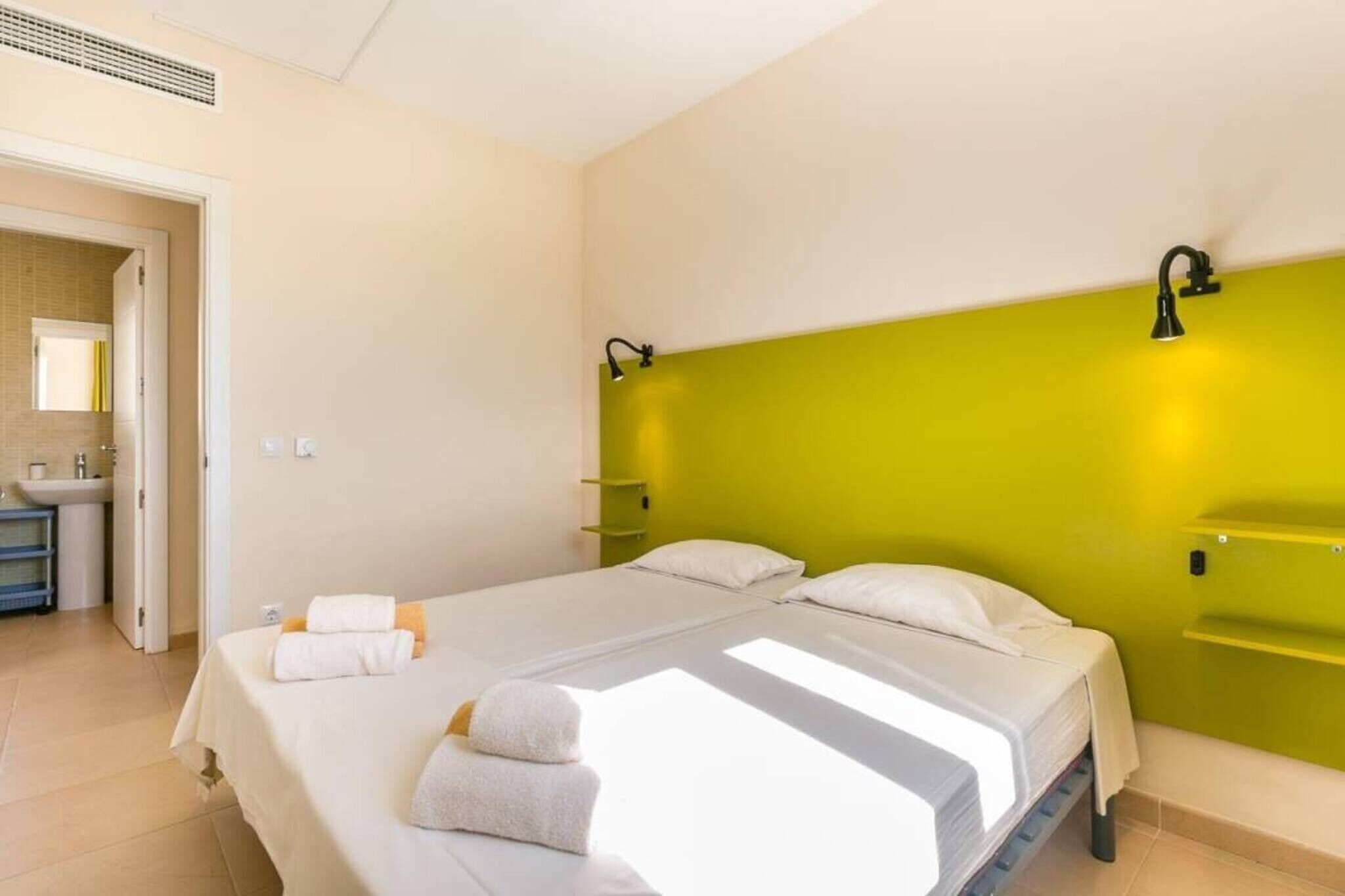 Ein Hotelzimmer mit Bett, Bad und einer grünen Akzentwand.