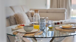 A breakfast table with a bowl, glasses, and a bottle.