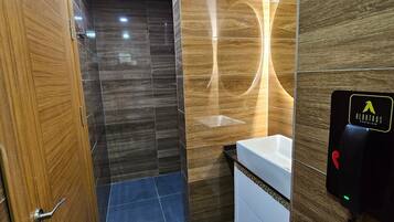 A modern bathroom with a wooden door, a sink with a mirror, and a toilet.